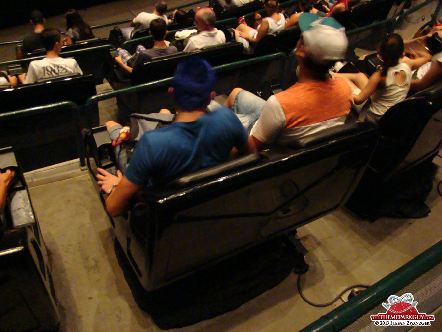 Brazilians strapped to moving chair (3-D cinema showing awful dinosaur movie)