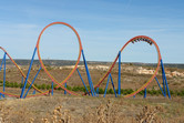 Huge looping roller coaster stretching beyond the park's borders