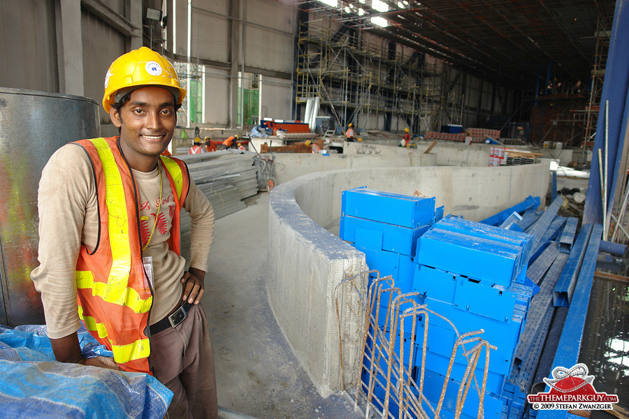 Bangladeshi worker posing in front of undisclosed dark ride