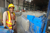 Bangladeshi worker posing in front of undisclosed dark ride